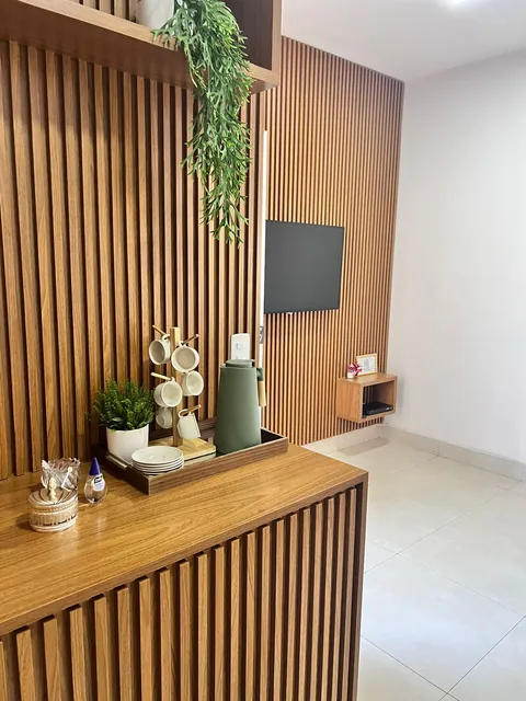 Recepção da DCON em Goiânia, com painel ripado de madeira e estação de café